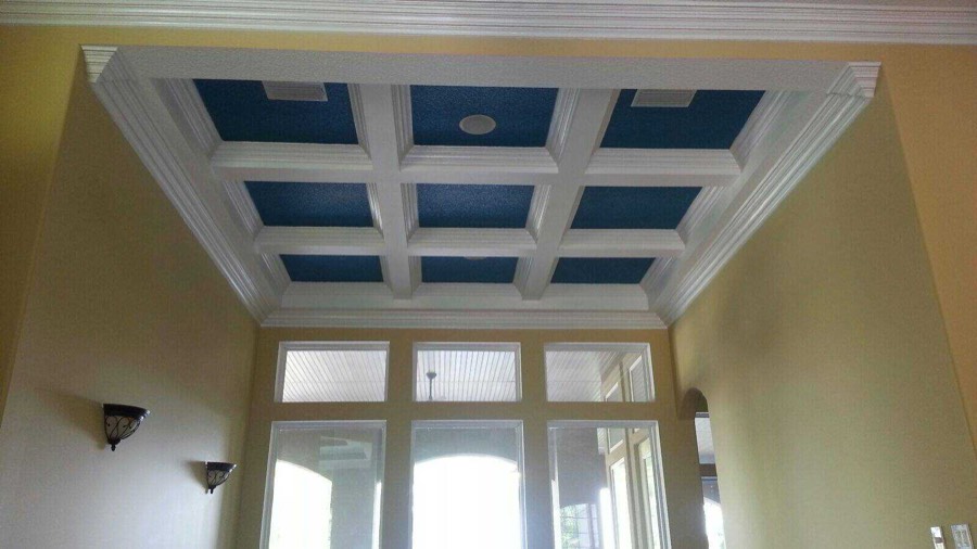 A coffered ceiling with white beams and deep navy recessed panels